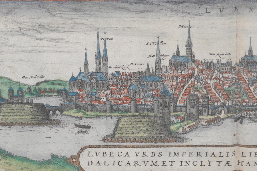 Profile view of Lübeck with the Trave River in the foreground and the city, with its many churches, in the background.
